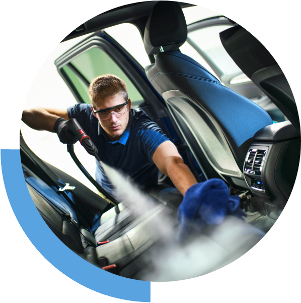 Person cleaning car interior with steam cleaner.